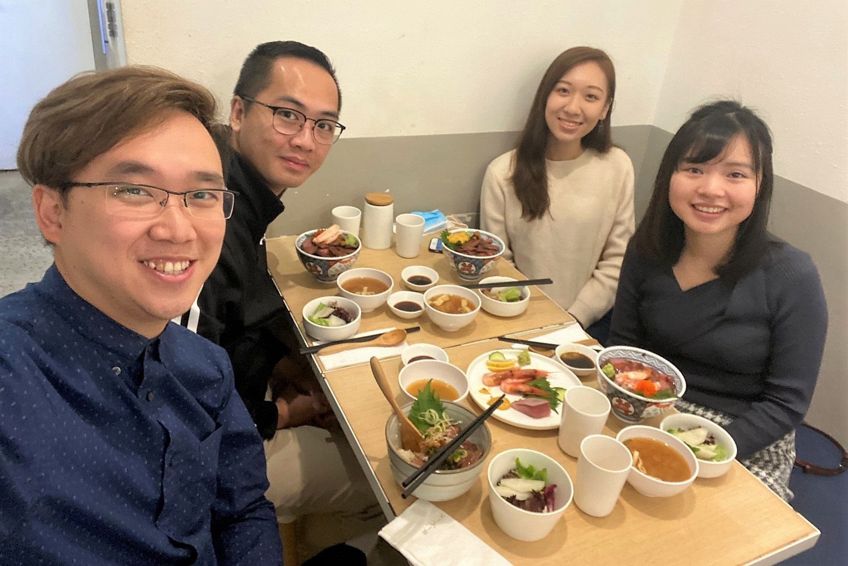 Four people sit around a restaurant table.