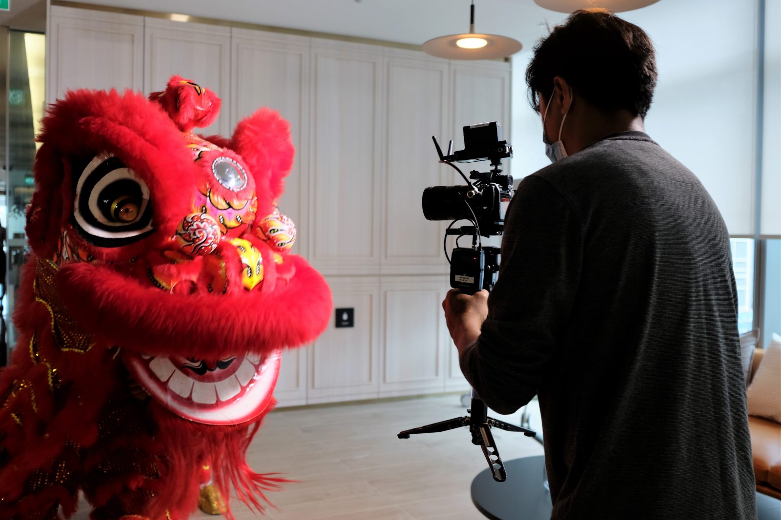 A camera operator films a lion dancer