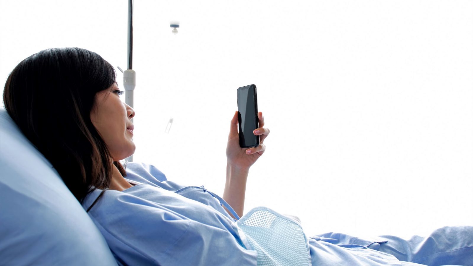 Woman in a hospital bed using a cellphone