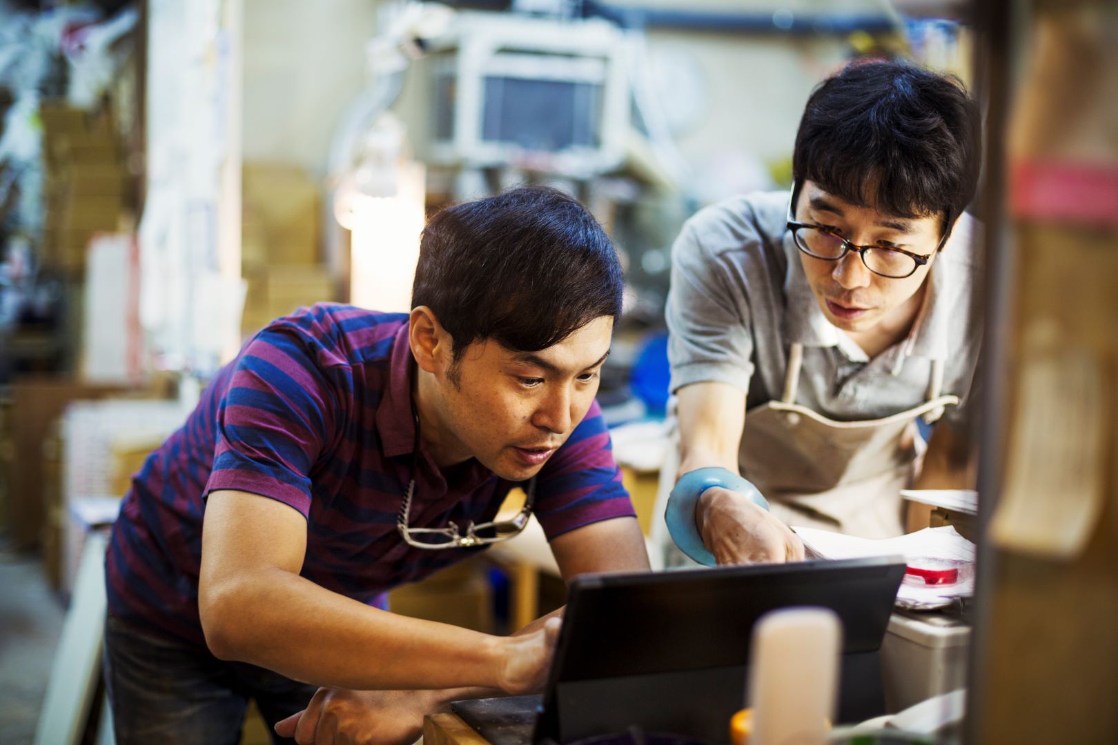 Two men using a laptop and working together