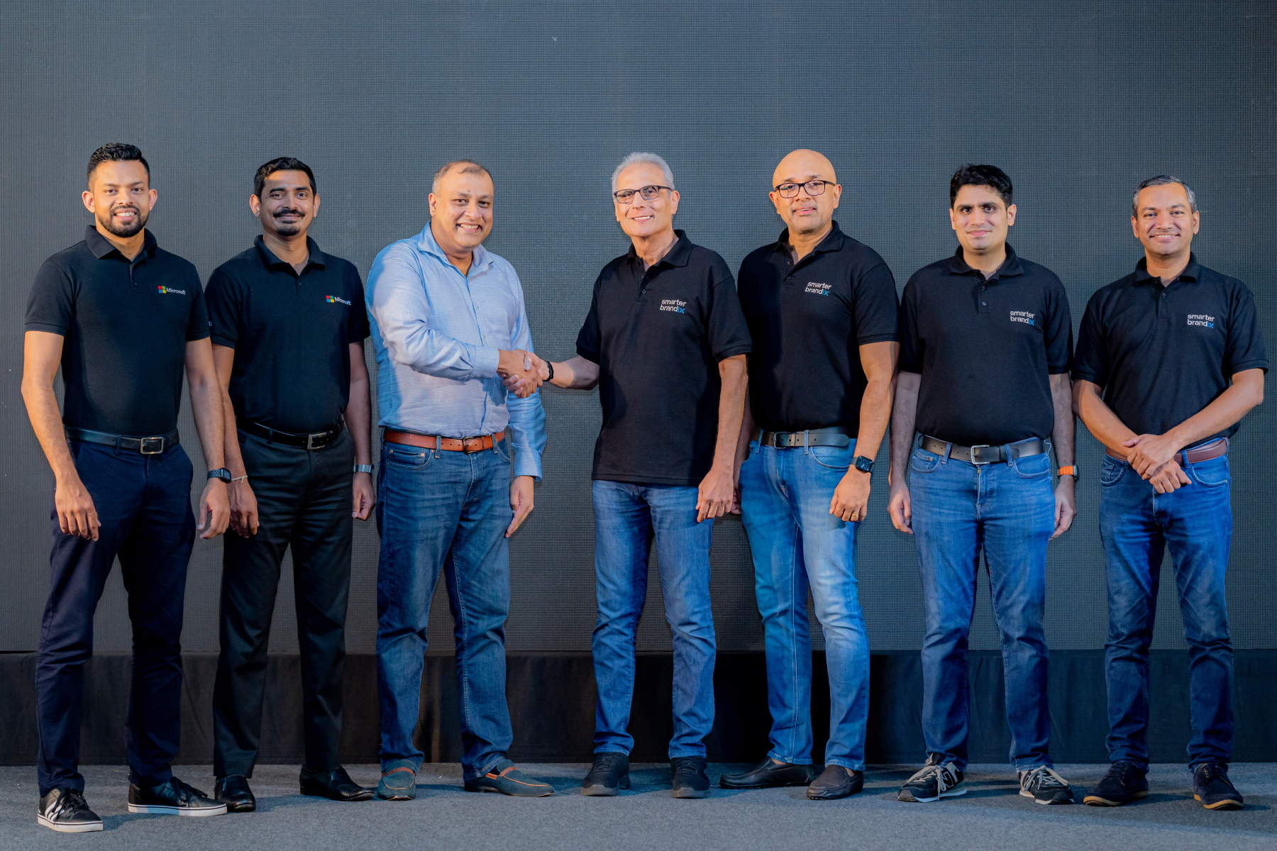 Group photo of male executives on stage at a corporate event