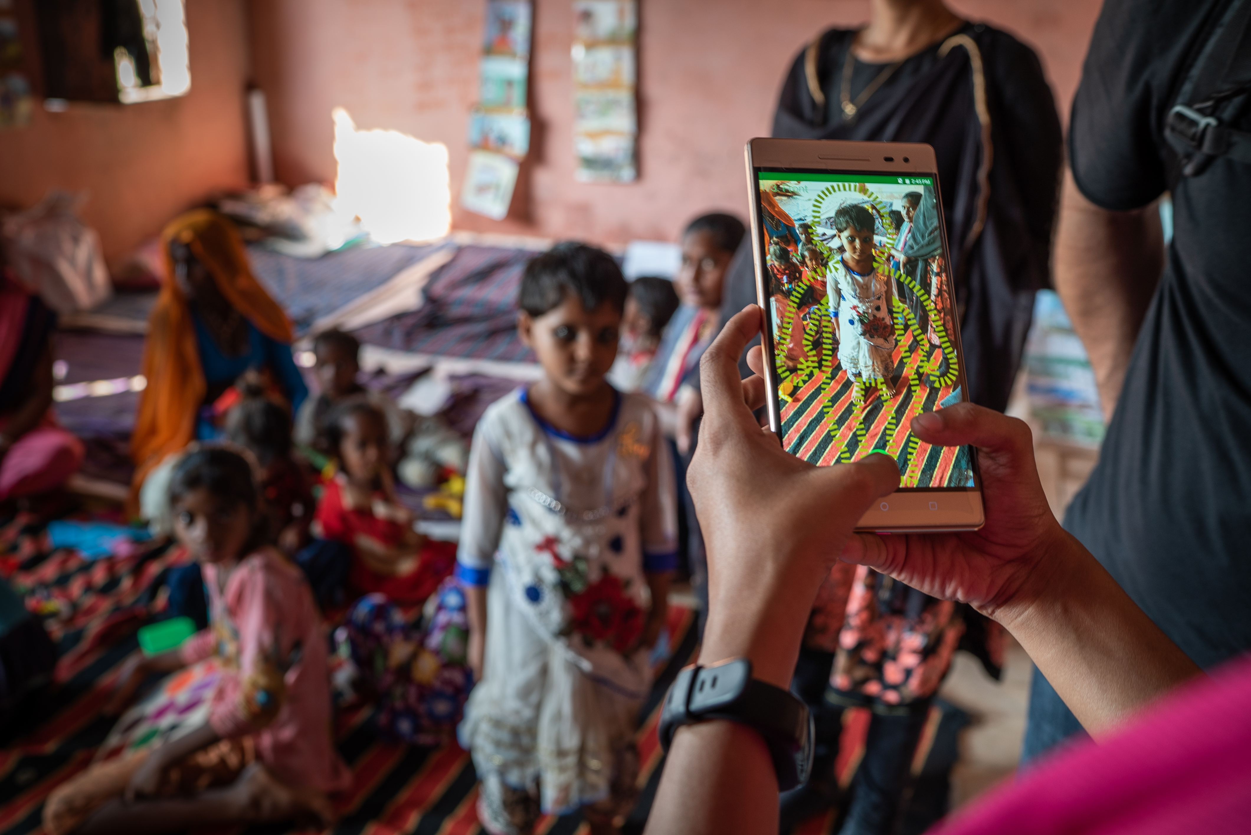 a person clicking a photo of a child with a phone