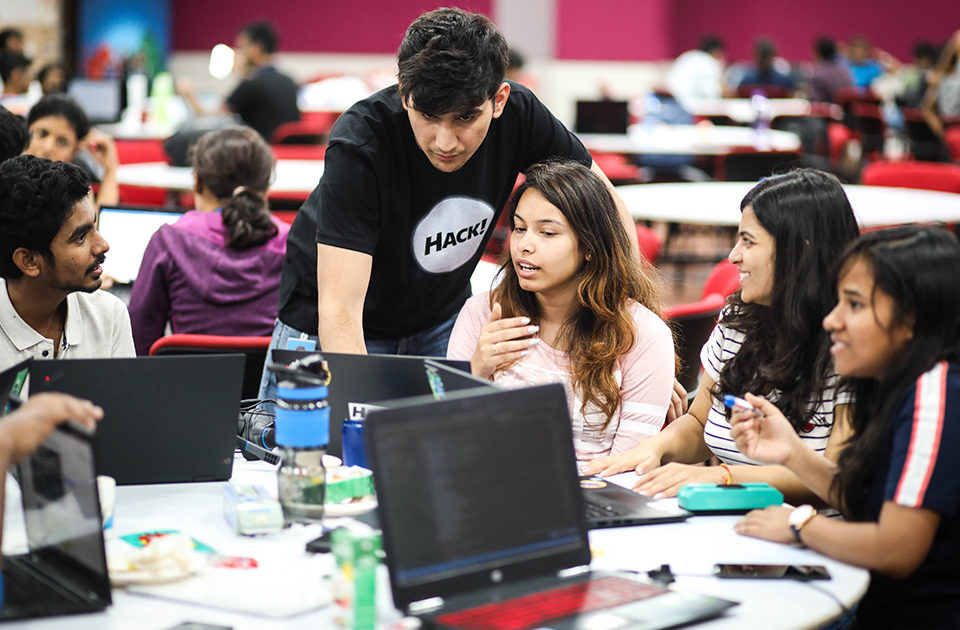 Groups of coders working on their computers at One Week Hackathon 2019