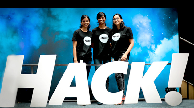 Three women smiling at the camera during a corporate event