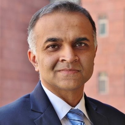 A man wearing a blue blazer smiling at the camer