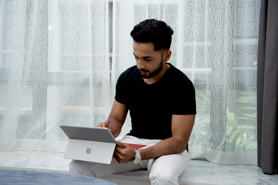 A man working from home on Surface tablet