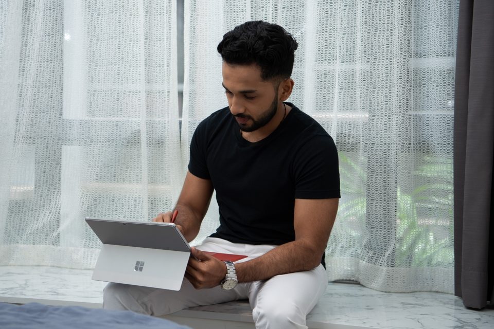 Photo of a man working from home using a Surface laptop