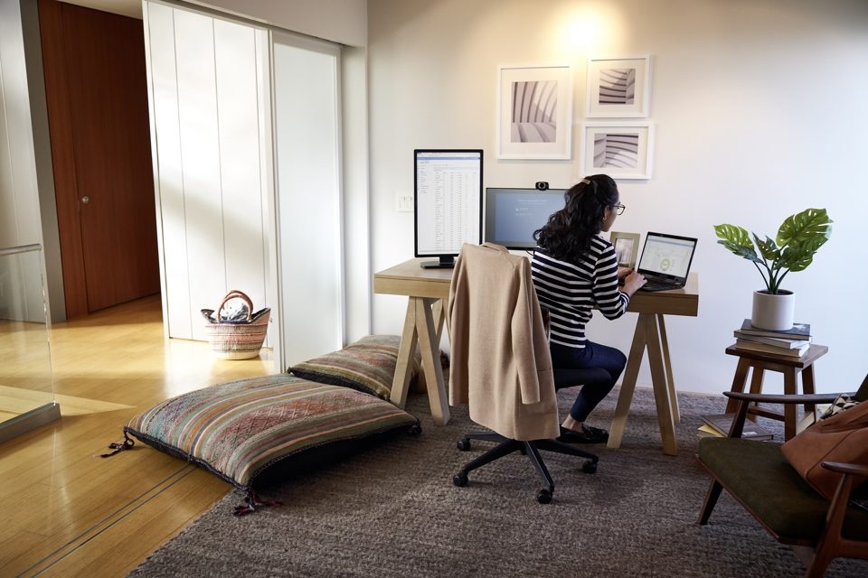 Photo of a woman working on a laptop at her home