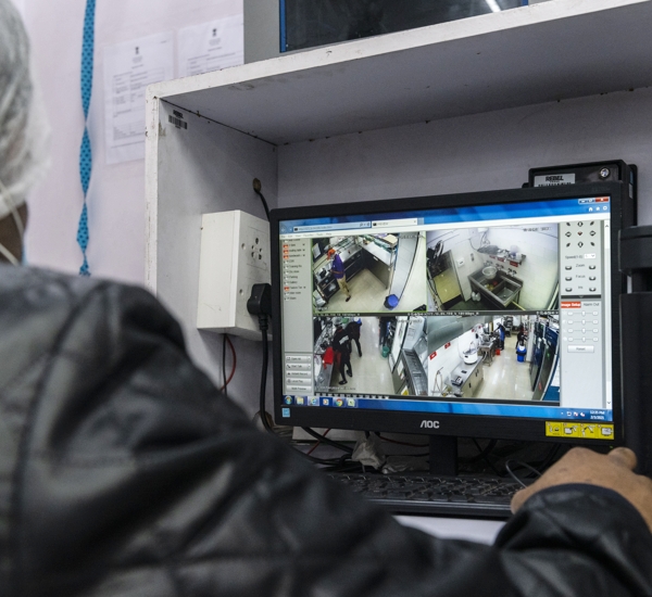 Photo of a man looking at a video feed on a monitor