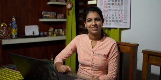 A woman sitting on a dining table and working on her laptop