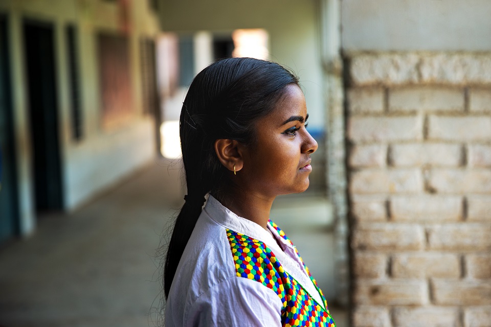 a side profile photo of a woman standing in a corridoor