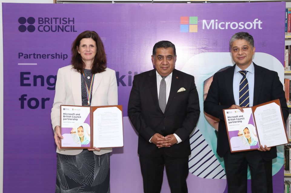 a woman and two men at a corporate event posing for a picture