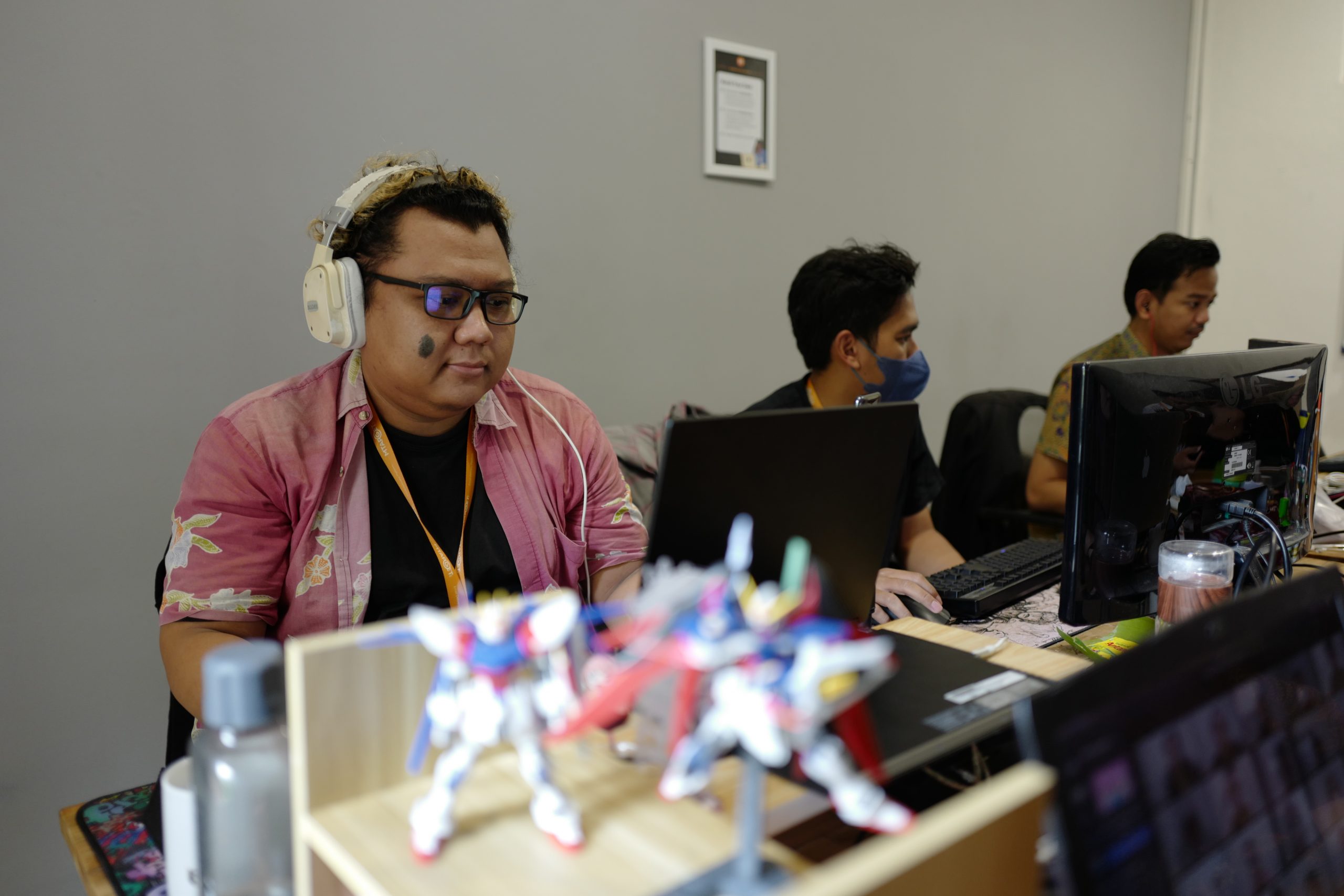 Three males working with their computer in an office