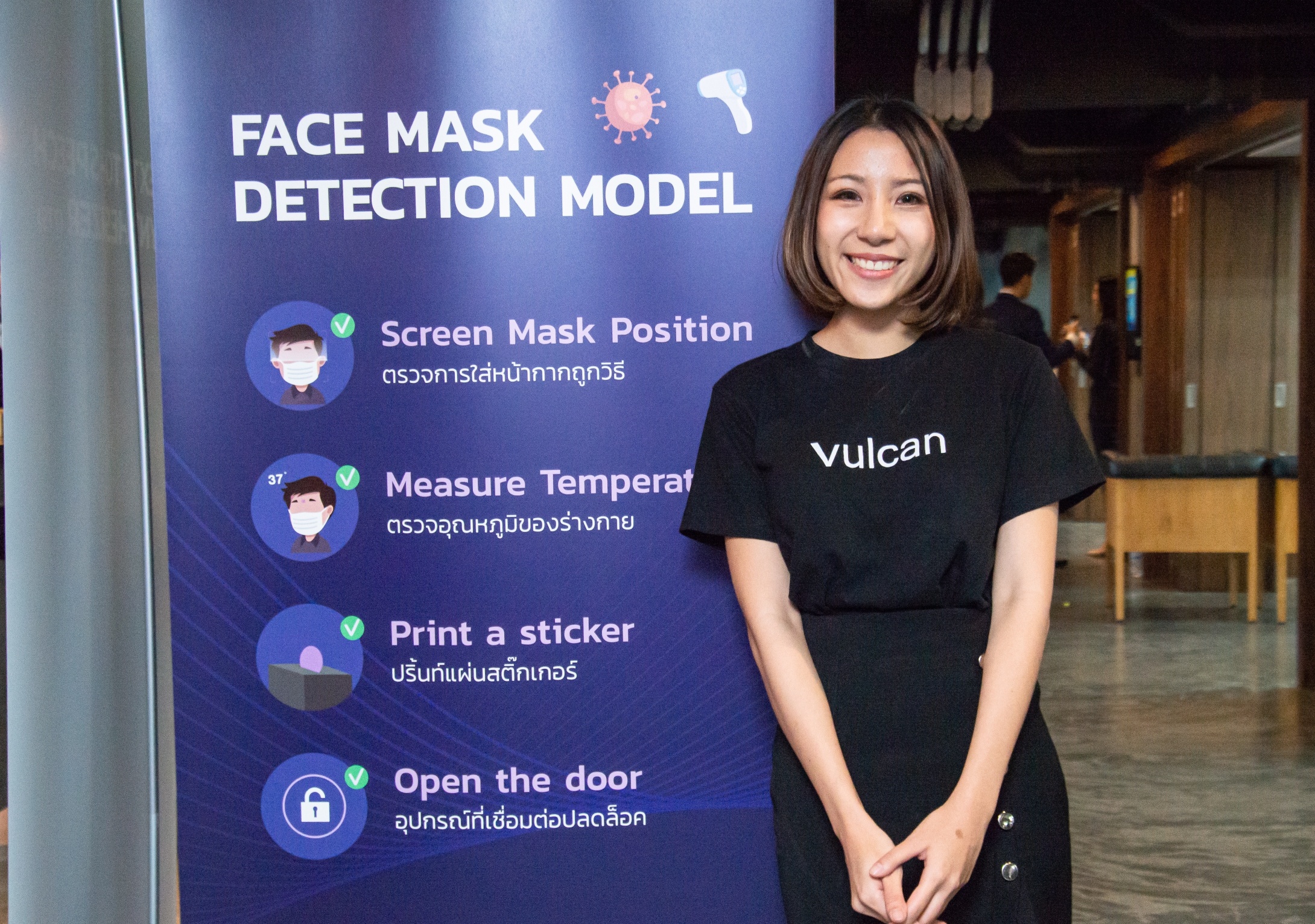 Smiling woman in front of blue/purple sign saying "Face Mask Detection Model"