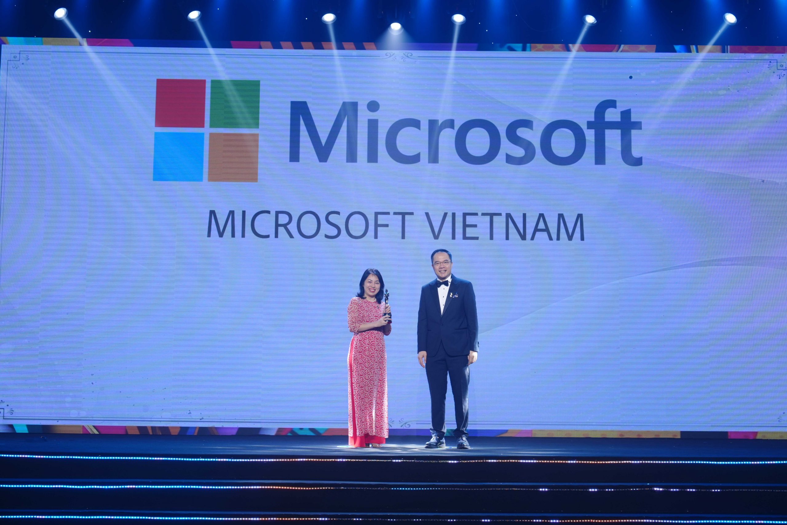 Representative of Microsoft Vietnam receiving trophy on stage