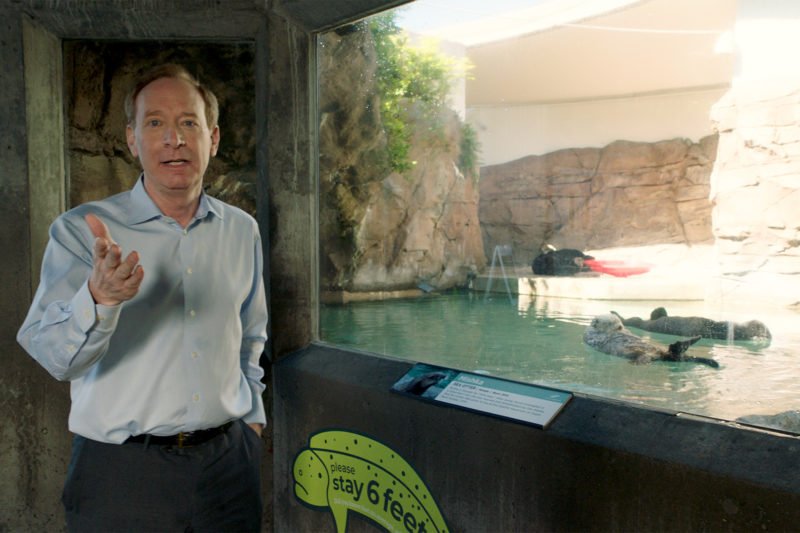 A man stands in front of an aquarium tank