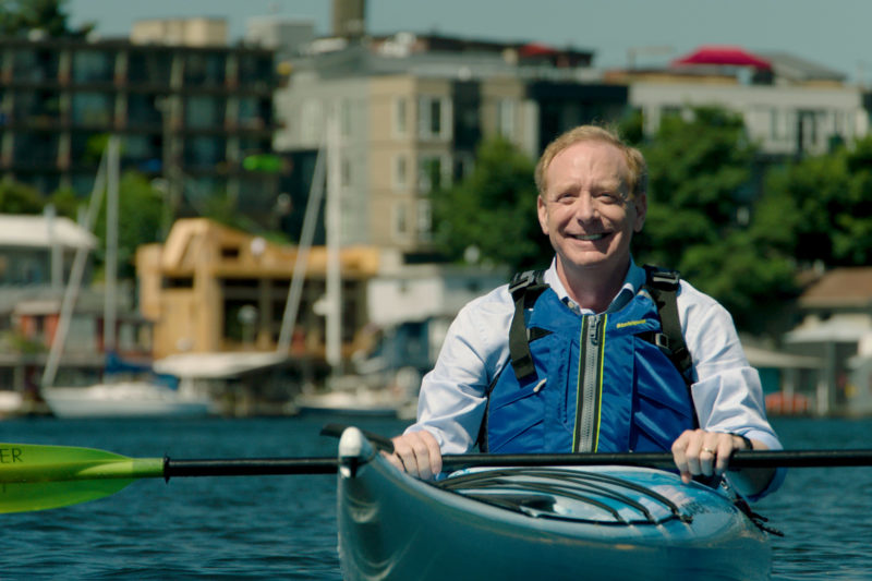 A man sits in a kayak on the water