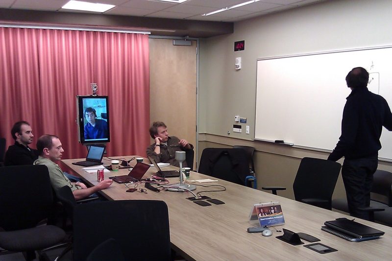 Man stands at whiteboard at meeting