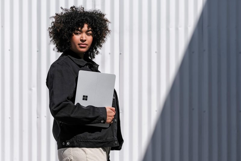 A woman holds a Surface laptop