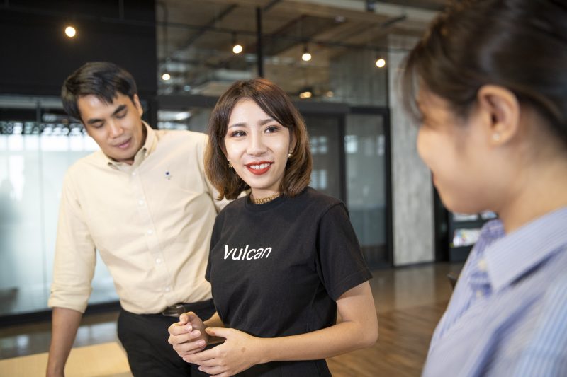 Methawee Thatsanasateankit, center, talks with Natthaphat Thaweekarn and Thanchanok Jiraphakorn, at the headquarters of Vulcan Coalition in Bangkok, Thailand. Thatsanasateankit co-founded Vulcan Coalition to develop new AI services in the Thai language and improve the quality of life for people with disabilities. Photo by Adryel Talamantes for Microsoft. 