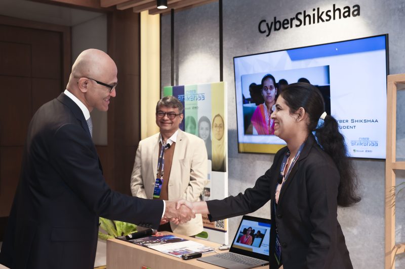 A man and a woman shaking hands while another man looks on