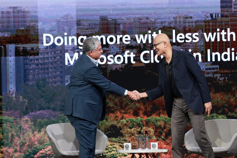 Nandan Nilekani shaking hands with Satya Nadella on stage