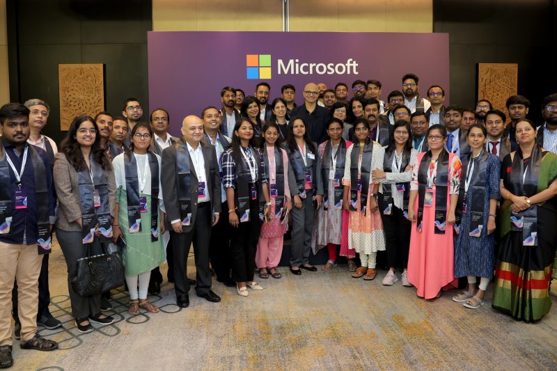 Satya nadella posing with developers