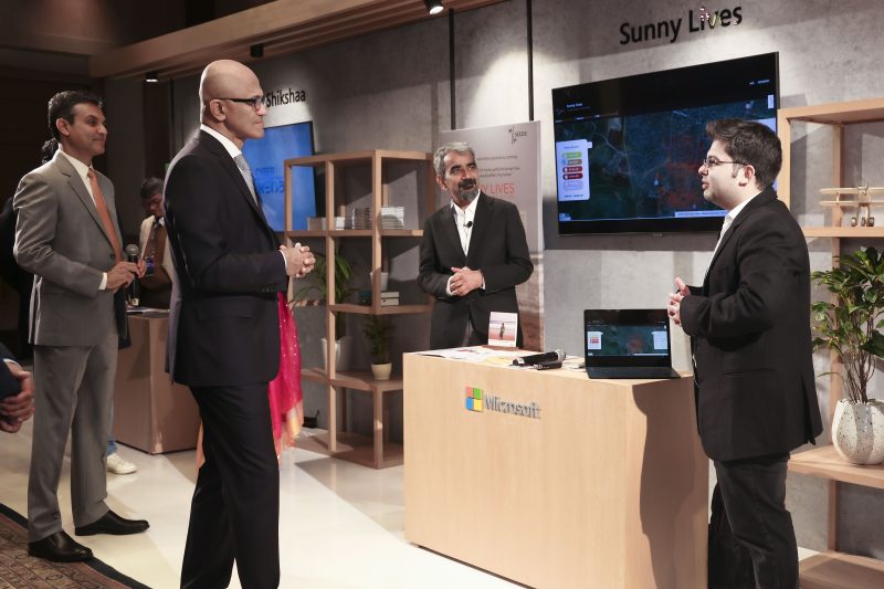 A group of four men interacting at a showcase booth