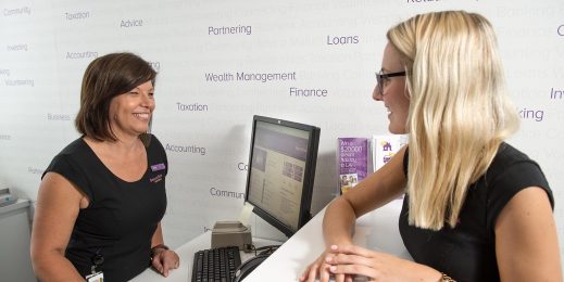 Two bank tellers smiling at work