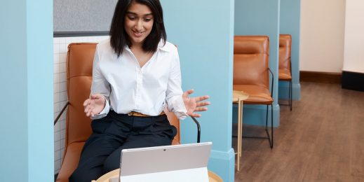 woman has hands up while looking at a surface device