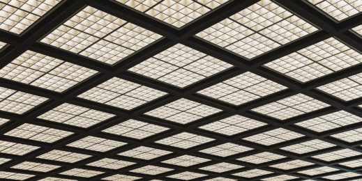 Up angle view of gridded square fluorescent lights in financial office