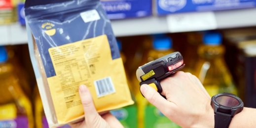 A retail worker using a hand held scanner to check a barcode.