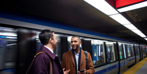 Image of two men standing at train station