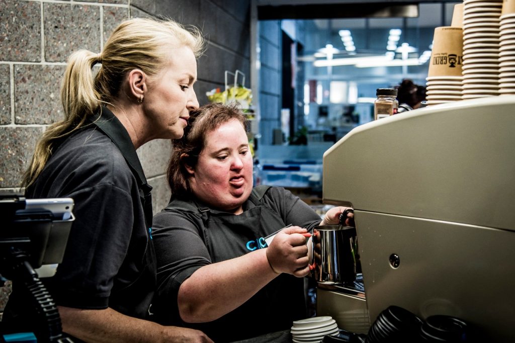 Worker with disability making a cup of coffee