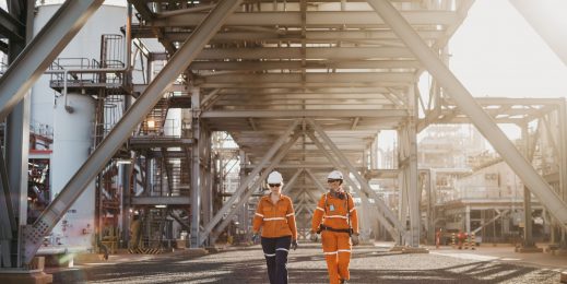 Two workers walking outside onshore plant