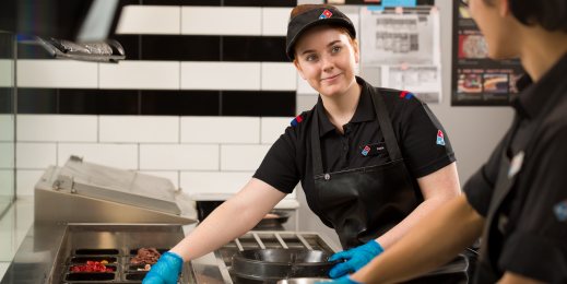 Dominos worker making a pizza