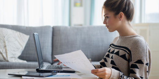 Young woman working with laptop in living room.