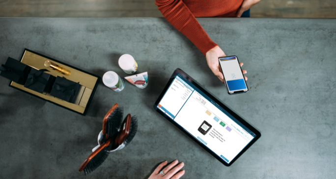 Birds eye view of a cafe service desk using a phone as payment