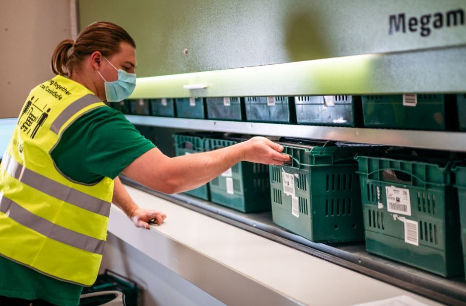 Male worker assisting shopping baskets