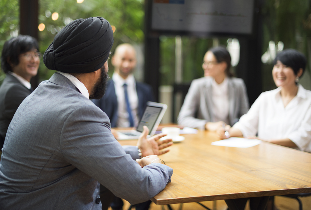 A group gathers around a table having a meeting in an office