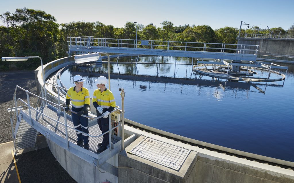 Two male adults standing infront of water site