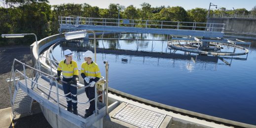 Two male adults standing infront of water site