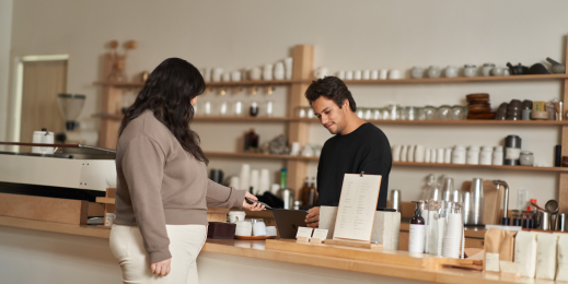 Customer using a mobile device to make a secure coffee shop purchase