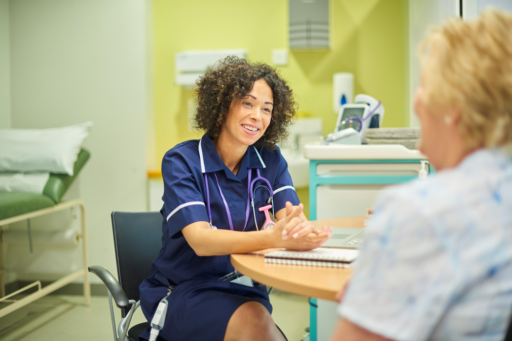 A female nurse is talking to a senior patient in a clinic triage.