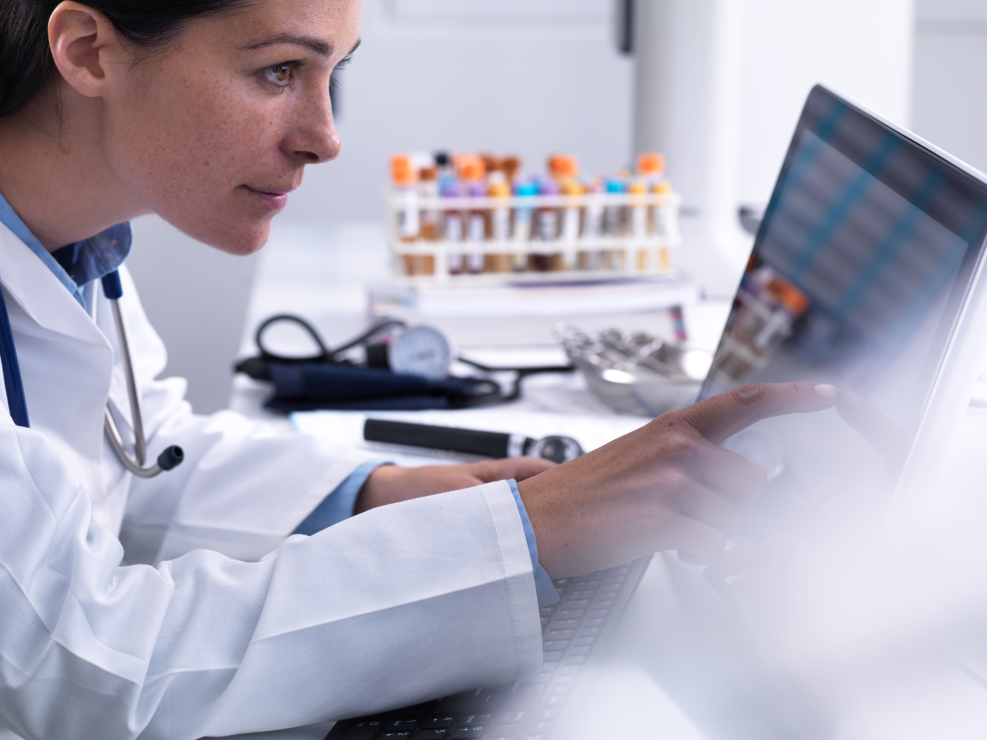 Doctor accessing a patients details using a touch screen computer in a clinic.