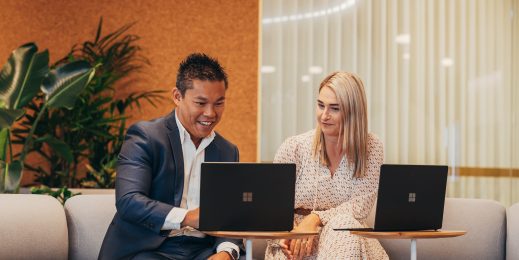 Two adults having a meeting with Microsoft Surface laptop