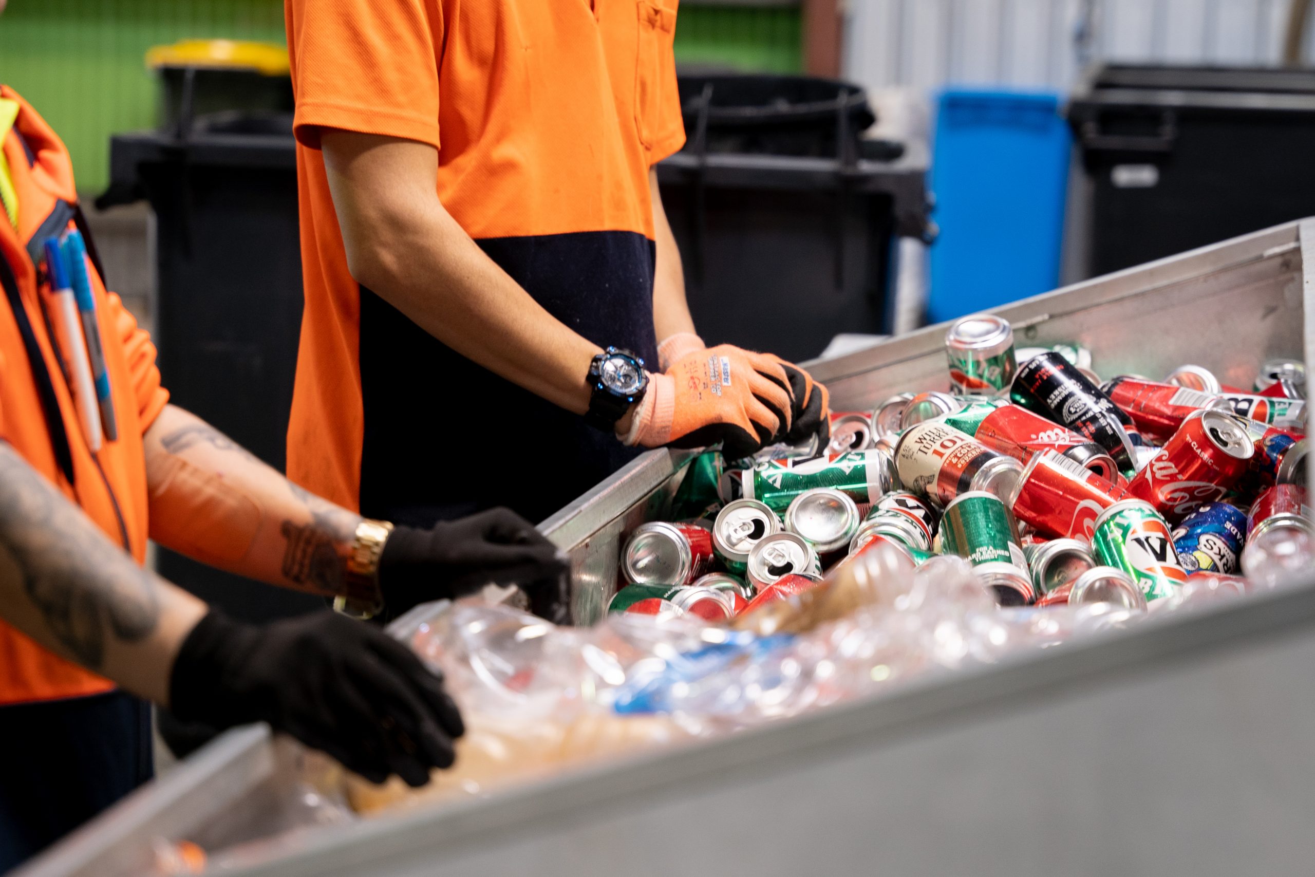 Close up of workers sorting through plastic containers