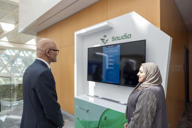 A Saudi woman interacting with Microsoft Chairman and CEO Satya Nadella at an event booth