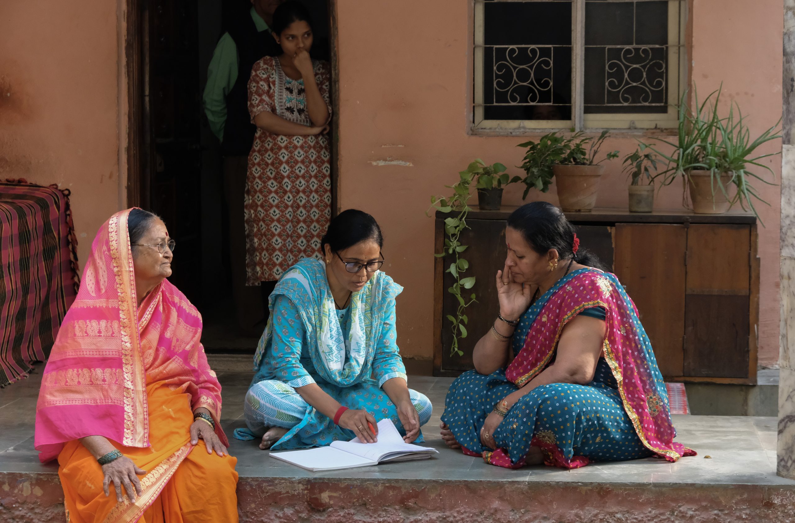 Three women sitting in on a step