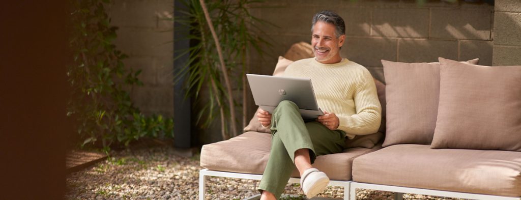 Uma pessoa sentada numa cadeira com um computador portátil